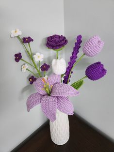 a white vase filled with purple and white flowers