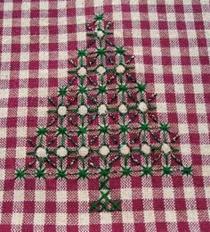 a red and white checkered table cloth with a small christmas tree made out of beads