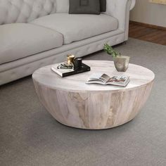 a white couch sitting next to a table in a living room on top of a carpeted floor