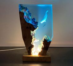 a sculpture made out of wood with blue and white light coming from the top of it