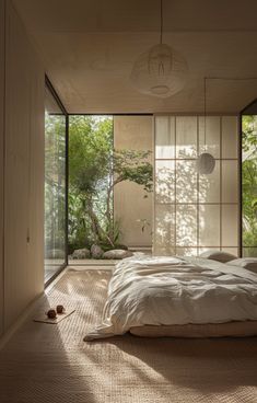 a bed sitting in the middle of a bedroom next to a wall with lots of windows