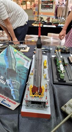 two people looking at model airplanes on a table