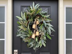 a wreath with bells hanging on the front door