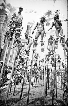 a group of people standing on top of wooden poles