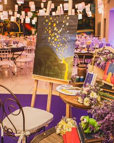 an easel sitting on top of a table covered in flowers