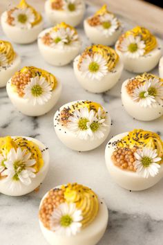 some white eggs with flowers on them sitting on a marble counter top, ready to be eaten