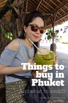 a woman holding a coconut drink with the words things to buy in phuket and what to avoid?