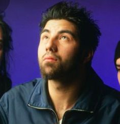 three people standing in front of a purple background