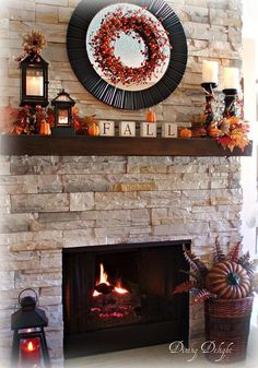 the fireplace is decorated with fall decorations and candles