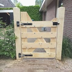 a gate made out of wooden boards and metal brackets on the side of a house