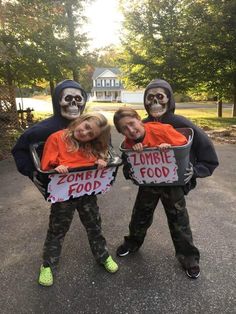 three children dressed up as zombies holding signs