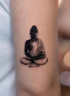 a small buddha tattoo on the arm