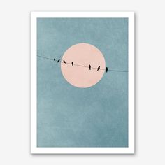 birds sitting on a wire with the moon in the background