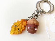 two acorns with faces are attached to a keychain