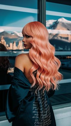 This voluminous style pairs rose gold ombre with pumpkin orange and coral pastel hues, giving the waves a retro-inspired twist. Dark roots transition seamlessly into lighter peachy tones, adding depth. A bold and glamorous option, it celebrates the peach hair color 2025 trend. Color 2025, Retro Waves, Pastel Hues