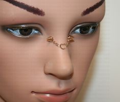 a mannequin's head with eyeliners and nose piercings on it