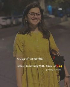 a woman with glasses and a yellow dress is standing in the middle of an empty street