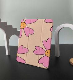 an ipad case sitting on top of a table next to a wooden block and white chair