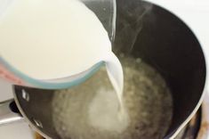 milk being poured into a frying pan on the stove