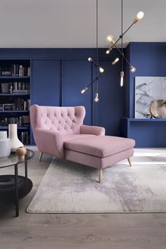 a living room with blue walls and pink couches in the center, surrounded by bookshelves