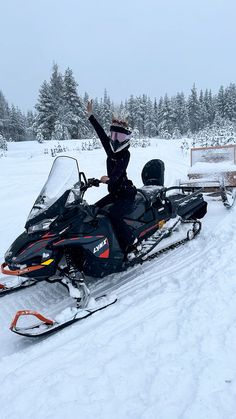 a woman riding on the back of a snow mobile