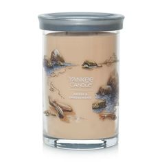 yankee candle with rocks and water on the bottom, in a glass jar against a white background