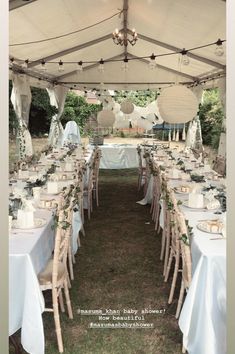 tables and chairs are set up under a tent for an outdoor wedding reception with white linens