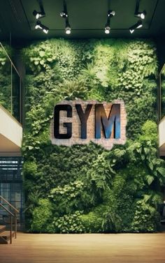 the gym wall is covered with green plants and letters that spell out'gym '