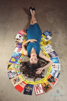 a woman laying on the floor surrounded by books