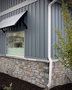 the side of a building with a stone wall and window