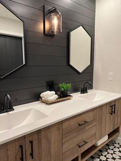 a bathroom with two sinks and mirrors on the wall