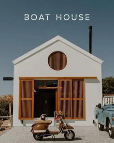 a scooter is parked in front of a house with the words boathouse above it