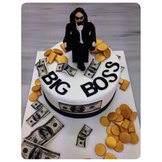 a cake decorated with money and a man in a black suit on top of it