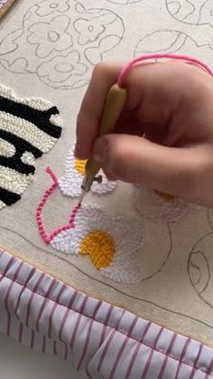 someone is working on an embroidery project with scissors