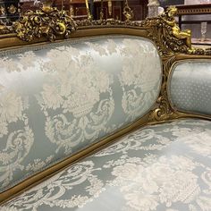 an ornate gold and blue upholstered couch