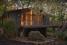 a small house in the woods with stairs leading up to it's second story