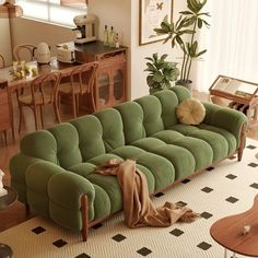 a green couch sitting in the middle of a living room