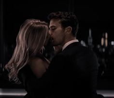 a man and woman kissing in the dark