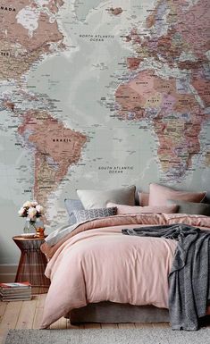 a bedroom with a map on the wall and pink bed linens in front of it