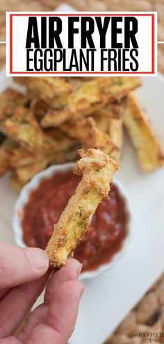 a hand holding up a piece of fried eggplant fries with ketchup on the side