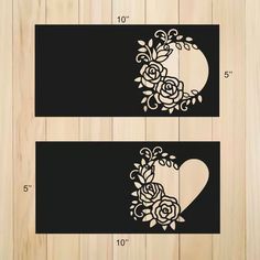 two pieces of black paper with white flowers on them and the shape of a heart