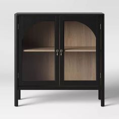 a black cabinet with two glass doors and one door open to show the inside of it