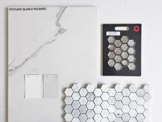 a white marble tile wall and floor next to a light switch