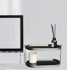 a laptop computer sitting on top of a desk next to a cup and pen holder