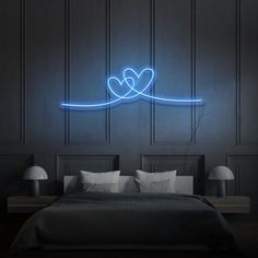 a bed in a room with a neon sign above it that says love on the wall