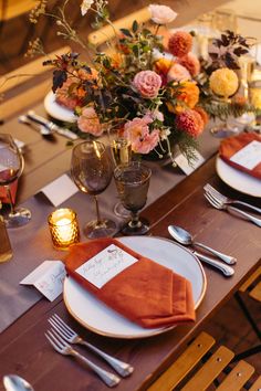 the table is set with place settings and flowers