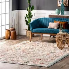 a living room filled with furniture and a large potted plant on top of a wooden table