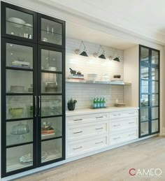 a kitchen with glass doors and white cabinets