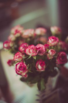 a bunch of pink roses sitting in a vase