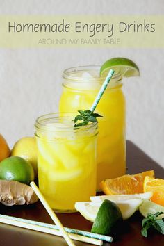 two mason jars filled with lemonade, limes and oranges on a table